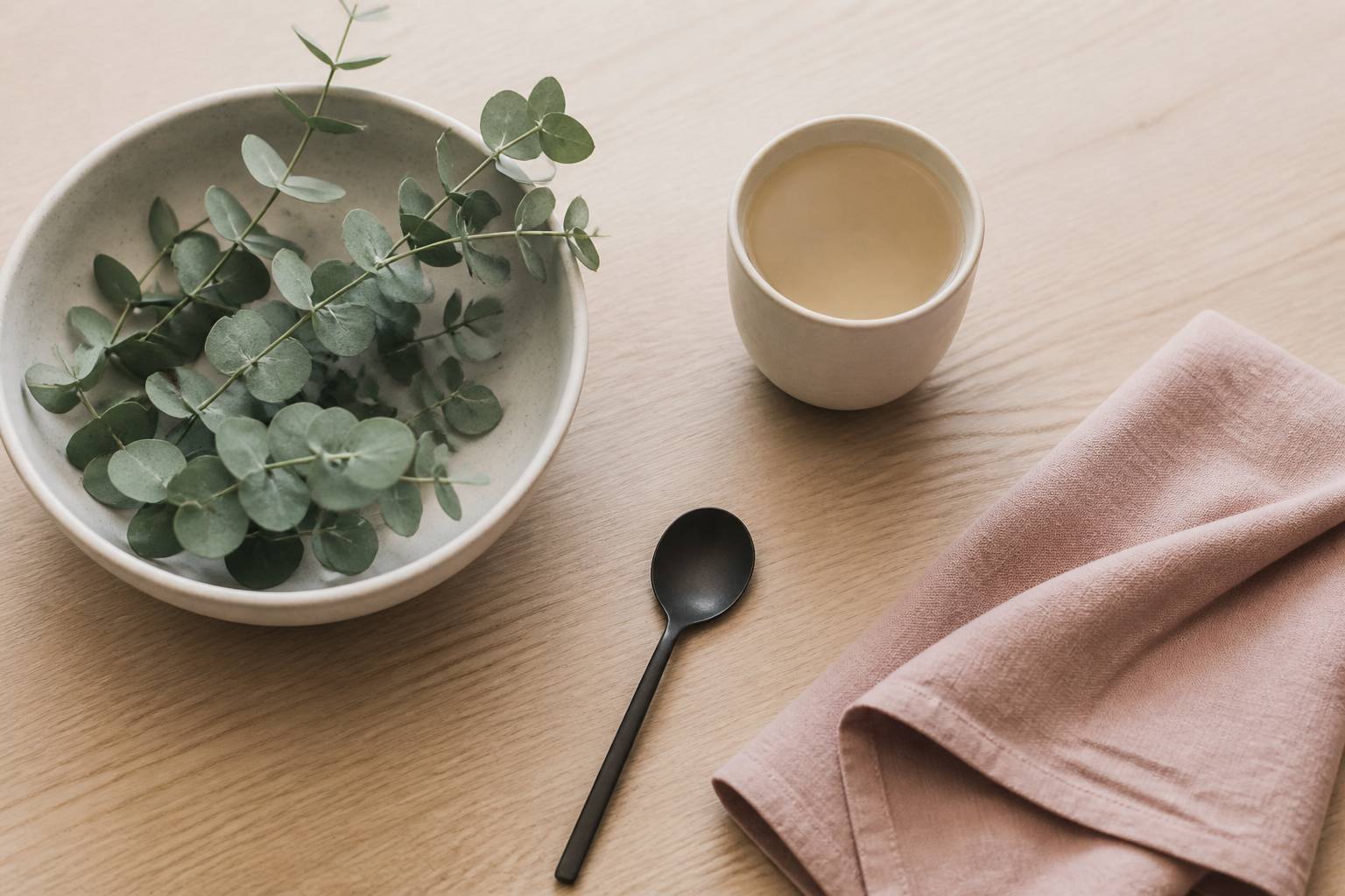 Feuilles d'eucalyptus fraîches dans un bol avec une tasse d'infusion